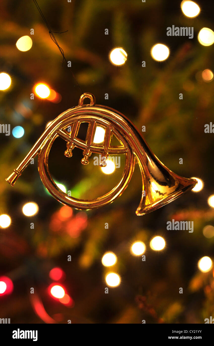 A Christmas decoration hanging on a well lit Christmas tree UK Stock Photo