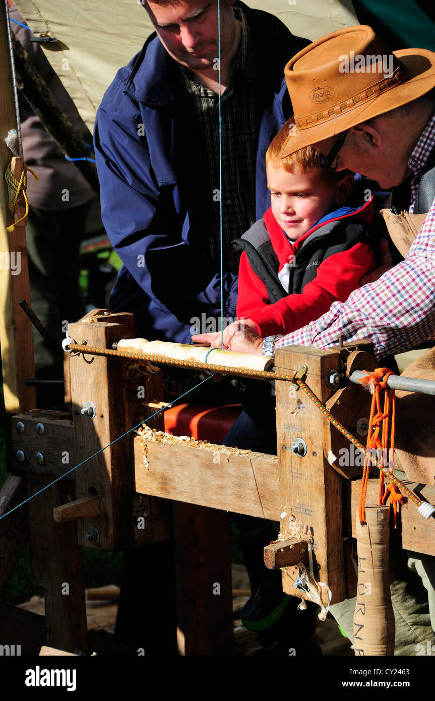Man demonstrating Pole Lathe Turning , on a treadle lathe,  making chair spindles at the Autumn Countryside Show Stock Photo