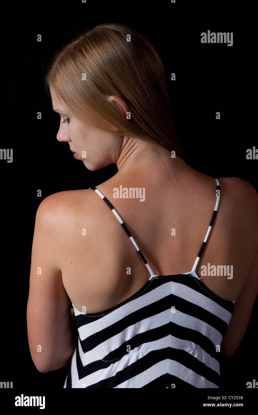 Pretty brunette woman with her back to the camera and looking over her ...