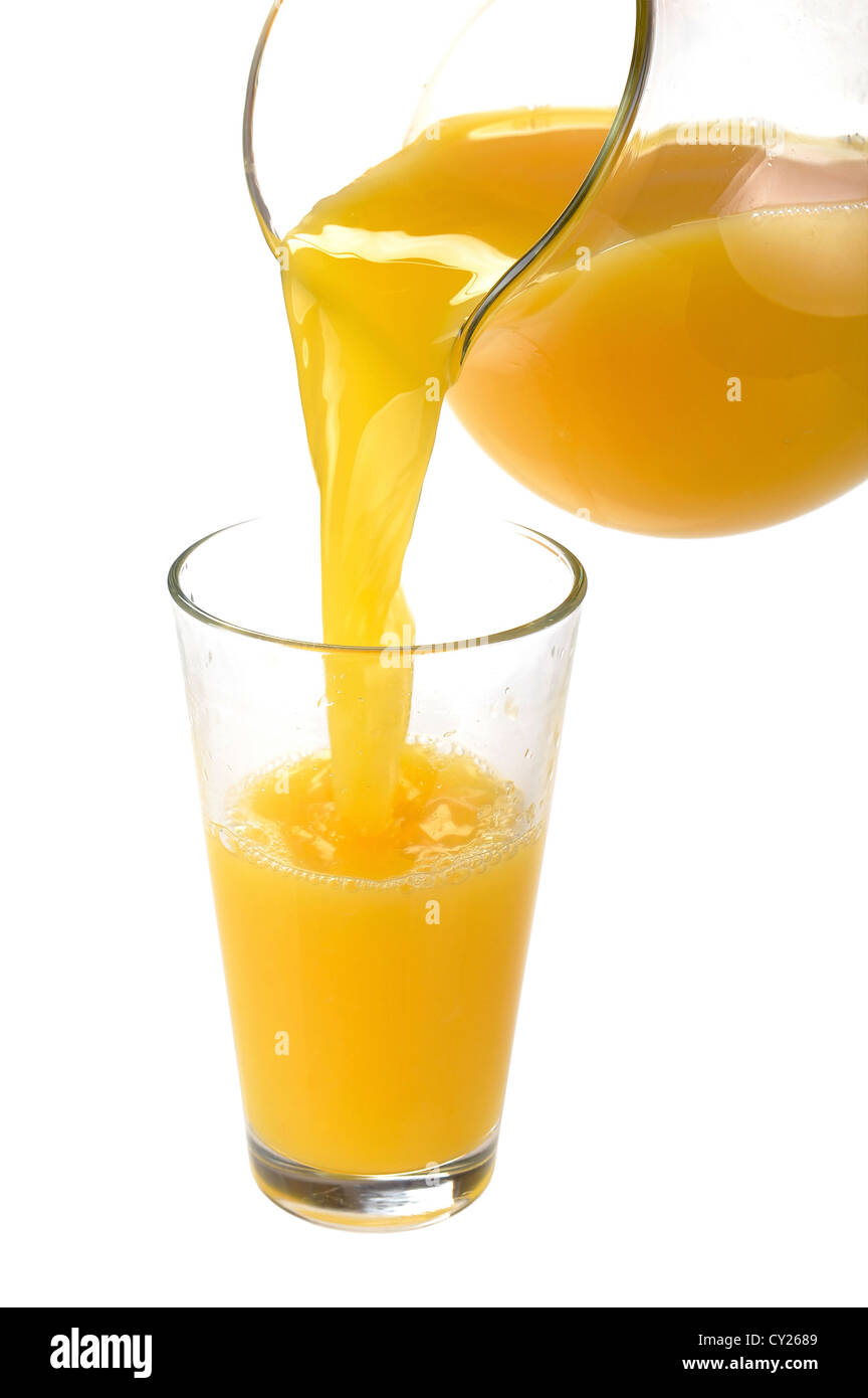 orange juice is poured from a jug into a glass Stock Photo Alamy
