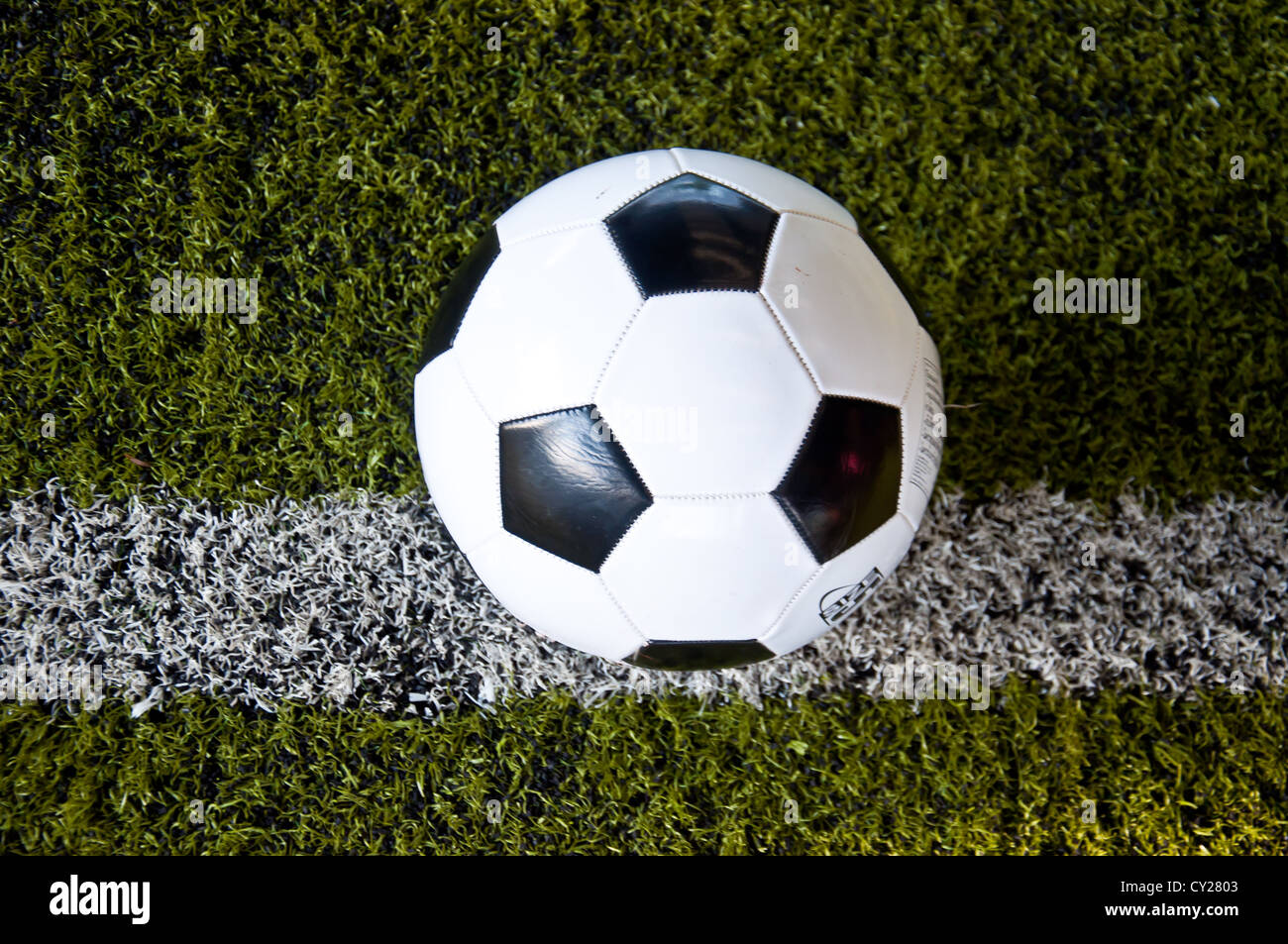ball on white line of artificial grass indoor football field Stock Photo