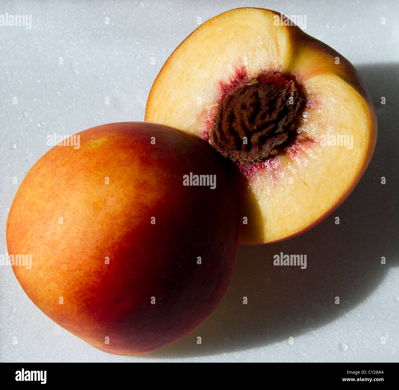 Peach in halves with stone visible. Stock Photo