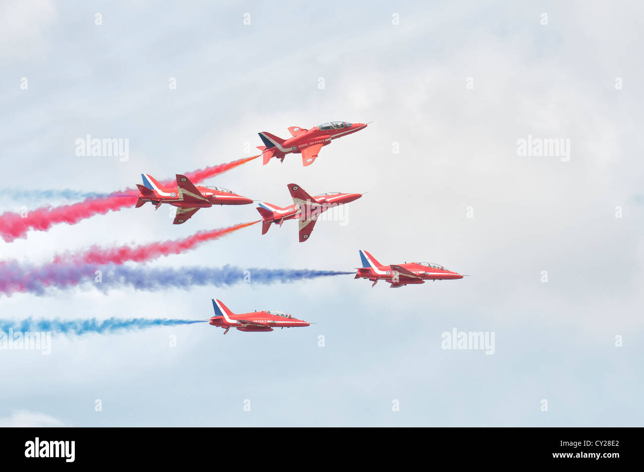 British Royal Air Force Military Aerobatic display team The Red Arrows break formation with smoke on at the 2012 Royal Internati Stock Photo