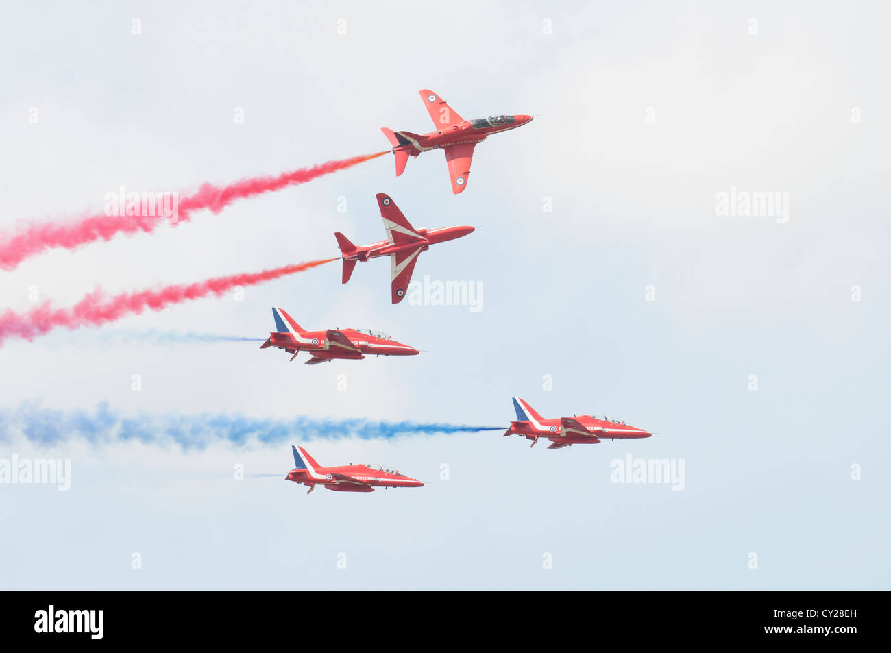 British Royal Air Force Military Aerobatic display team The Red Arrows break formation with smoke on at the 2012 RIAT Stock Photo