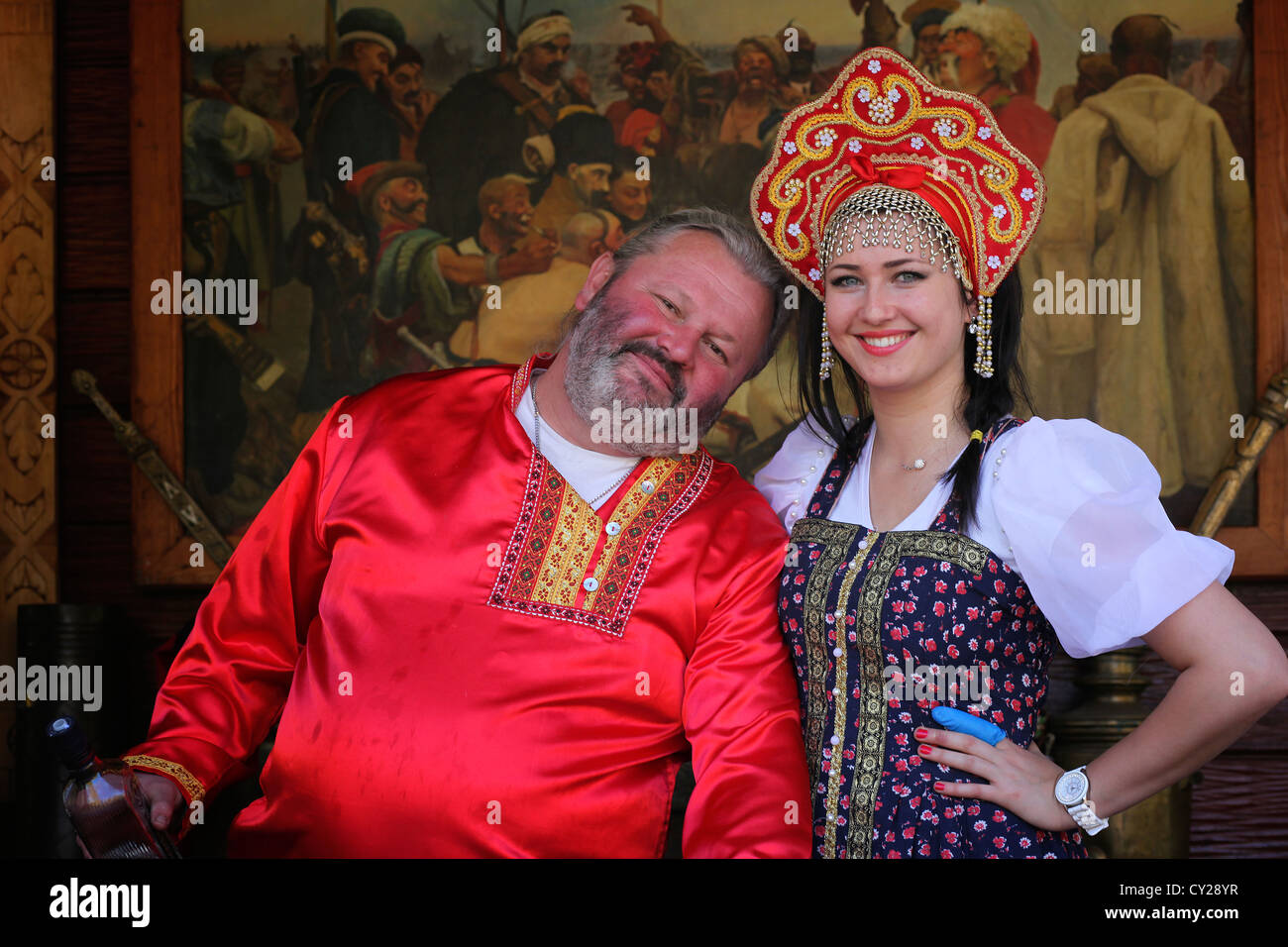 Ukrainian people in traditional clothing in front of the painting 'Reply of the Zaporozhian Cossacks' of Ilya Repin. Stock Photo