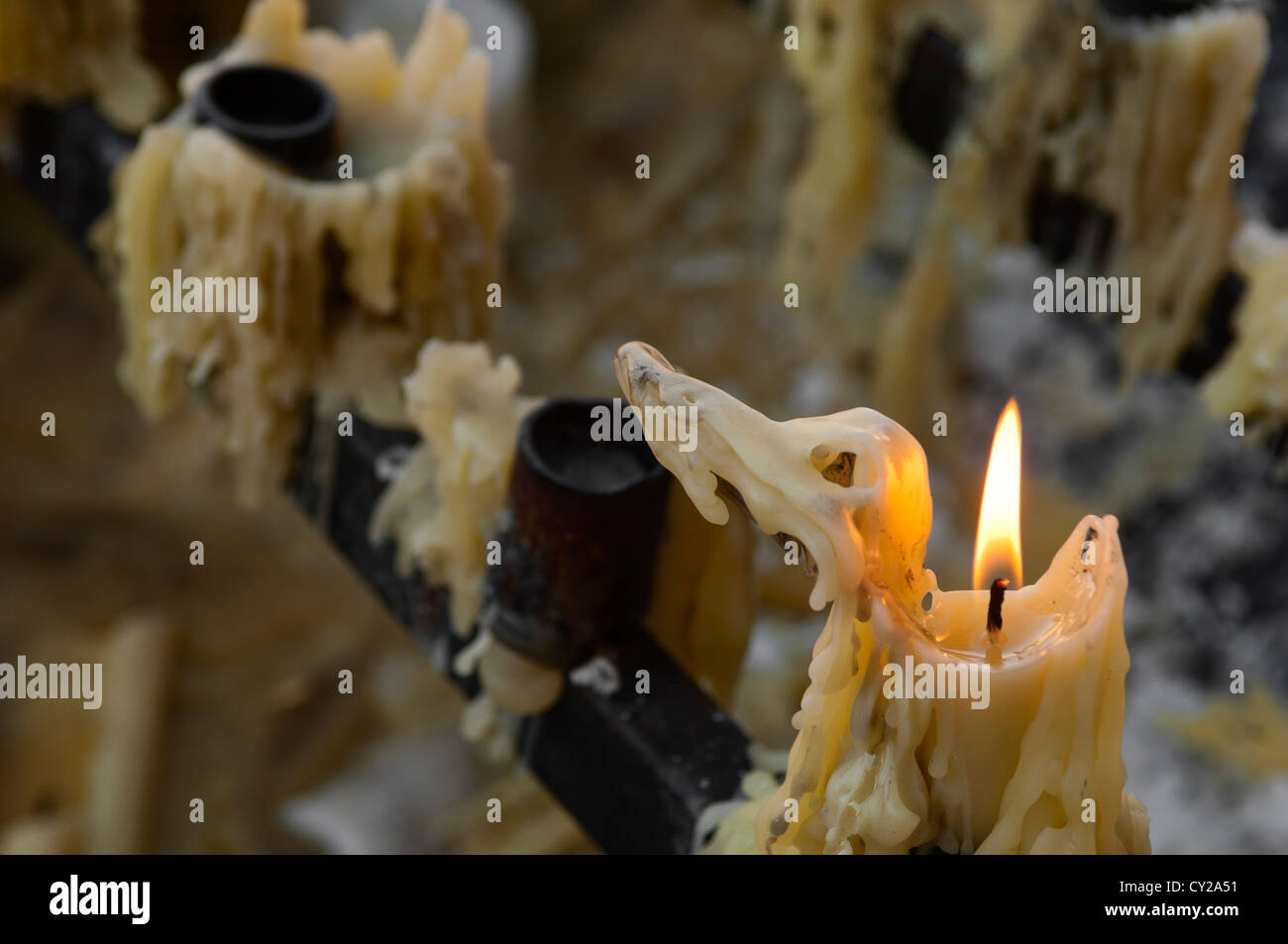 Votive burning candle in a candlestick and melted wax Stock Photo Alamy