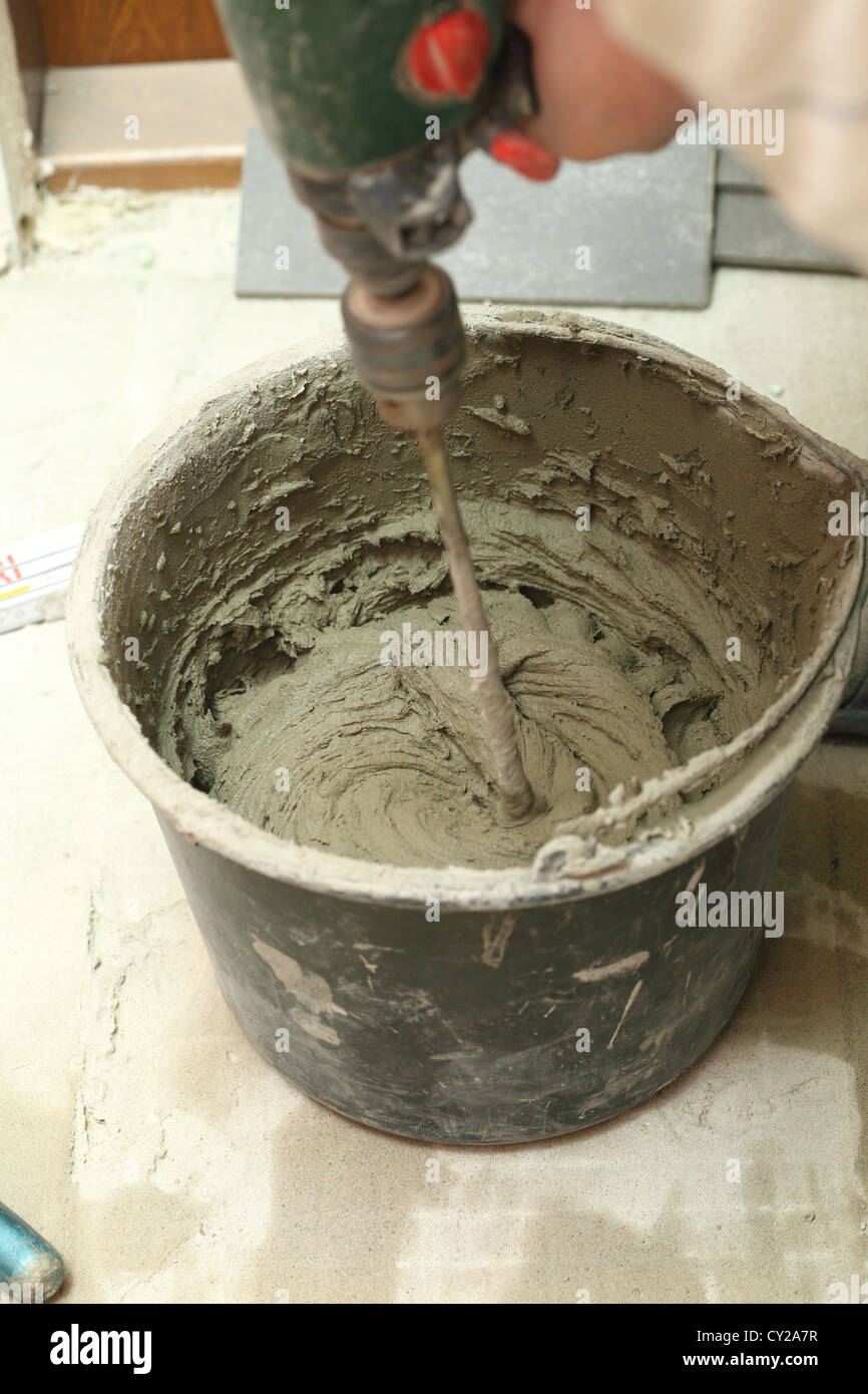 Builder mixing substance in bucket, cement mortar Stock Photo Alamy