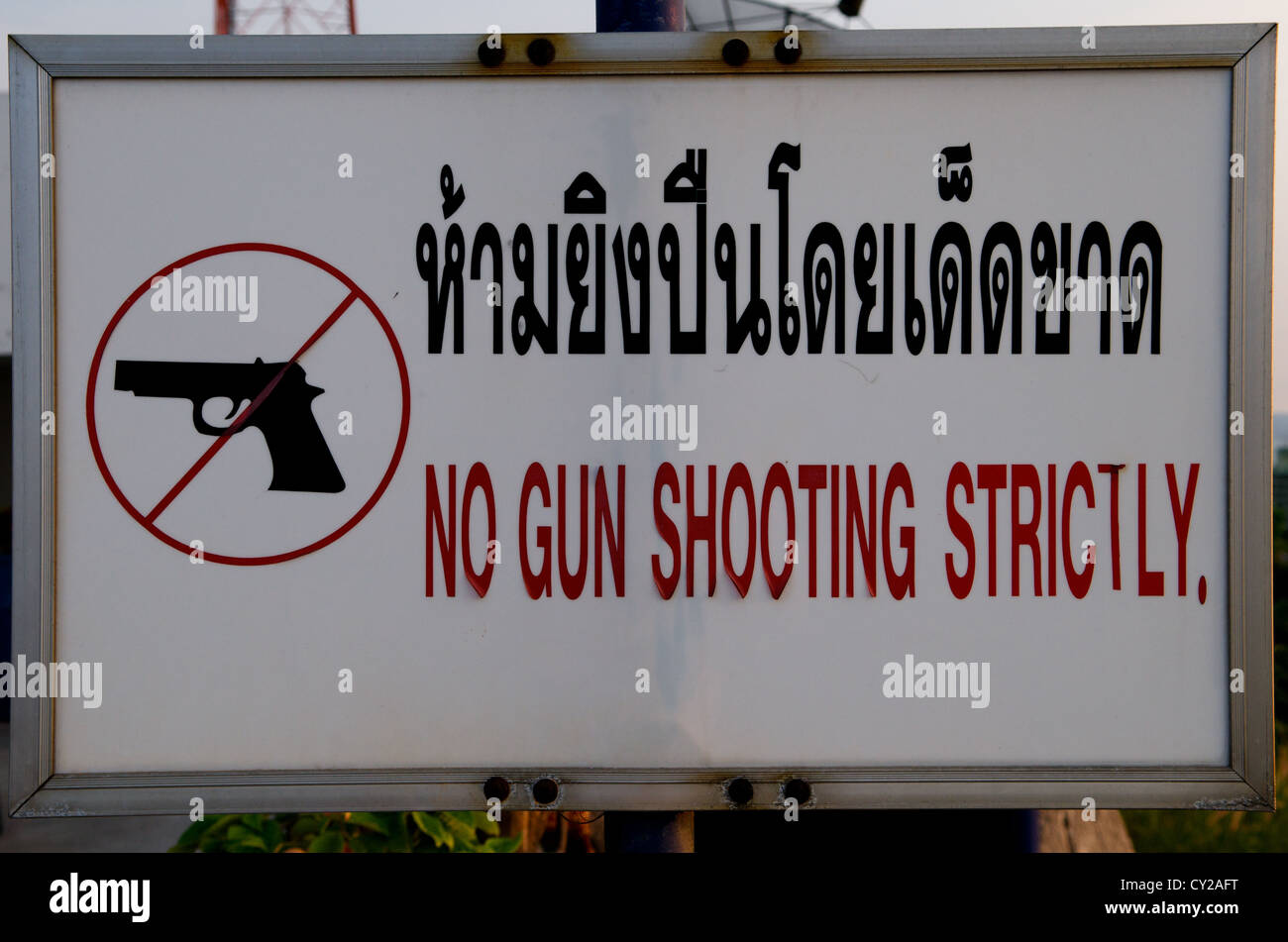 'No gun shooting strictly' sign in Thai & English, Pattaya, Thailand. credit: Kraig Lieb Stock Photo