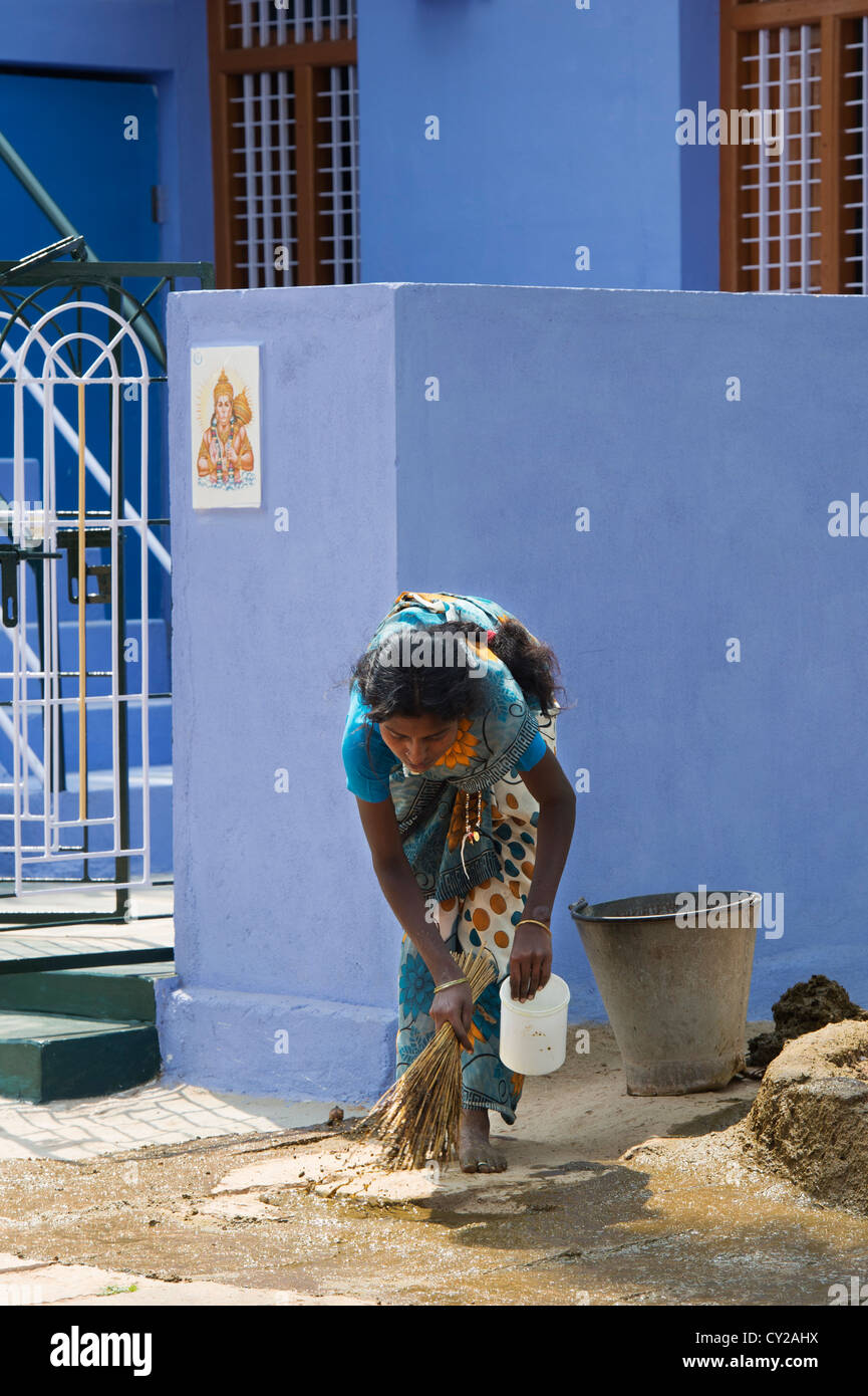 Indian custom of a woman spreading watered down cow dung outside the