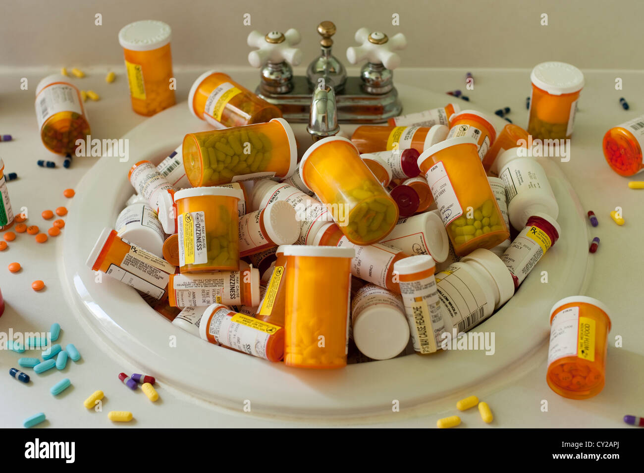Pills and pill bottles scattered over sink counter and in sink in