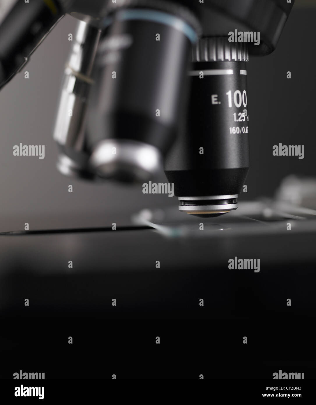 Lenses on the turret of a research microscope with glass slide on stage