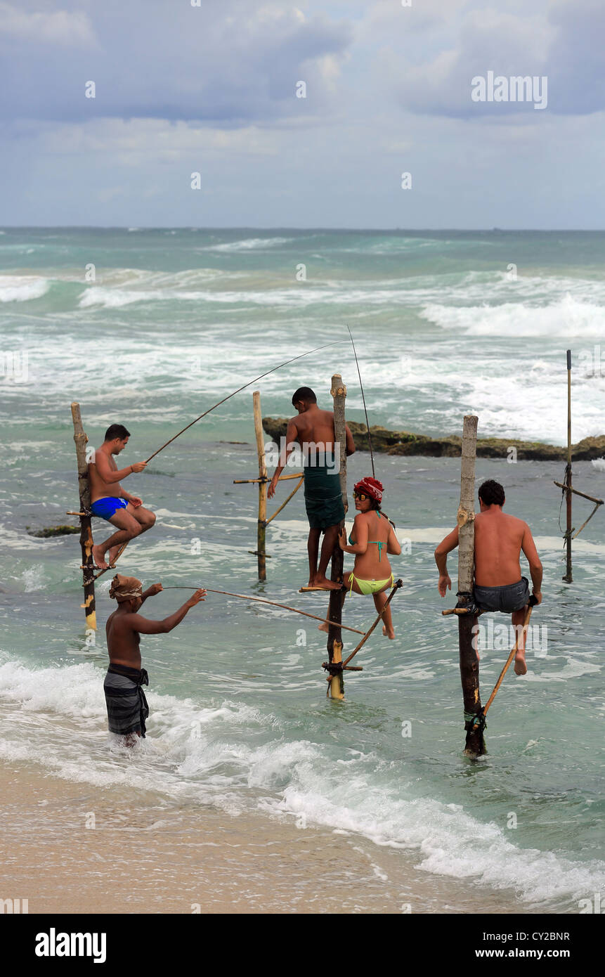 Tourists try stilt fishing at Koggala in Sri Lanka Stock Photo - Alamy