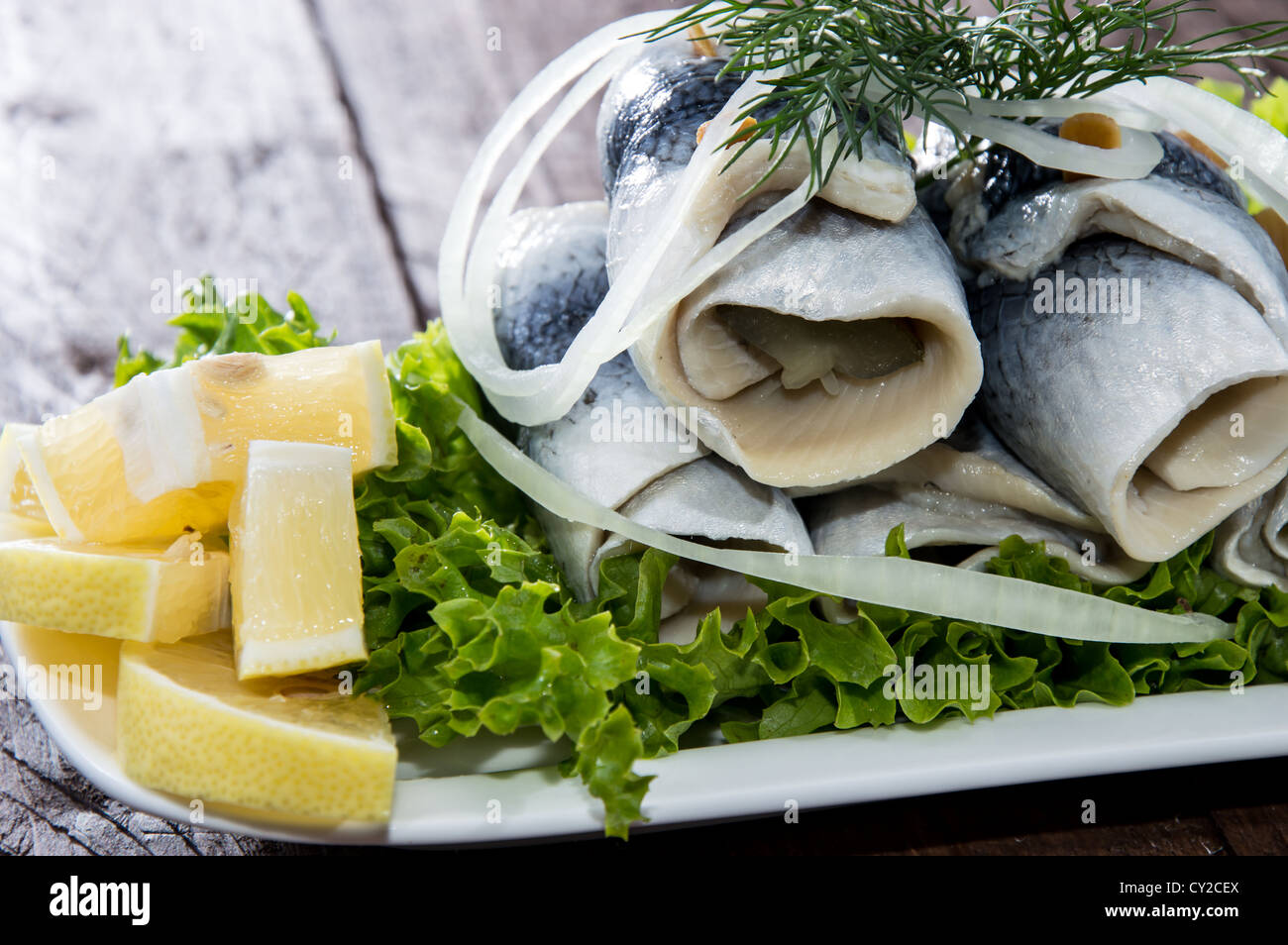 Fresh Herring Filet on a plate against wooden background Stock Photo