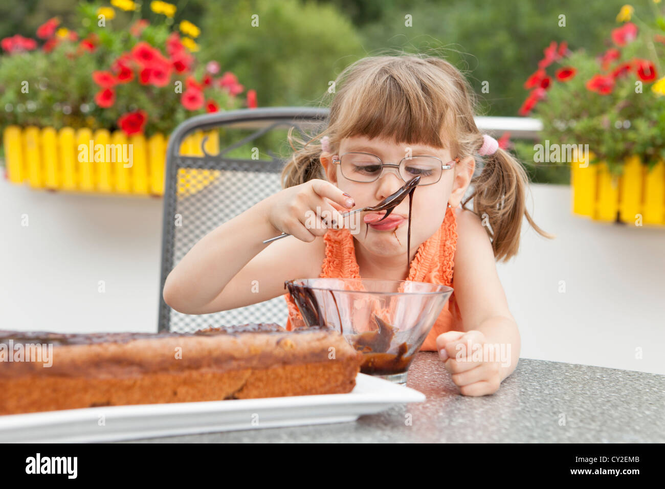Little girl decorating the chocolate cake Stock Photo