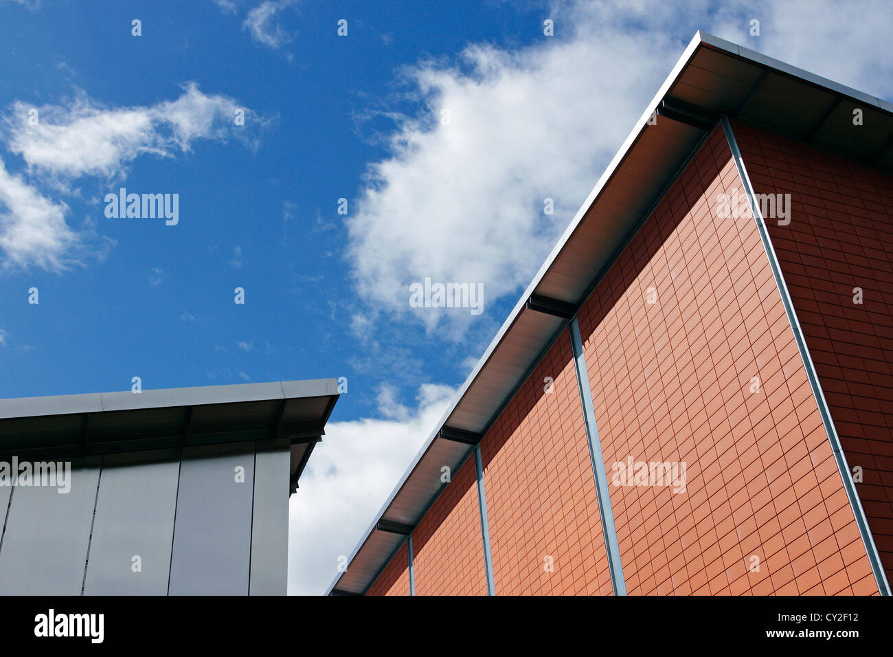 A modern red brick building photographed against a blue sky. Stock Photo