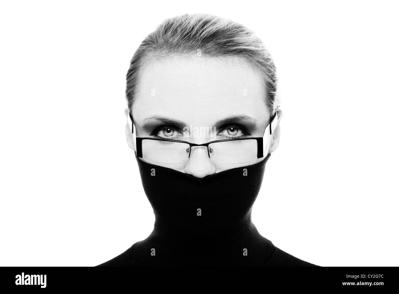 woman hiding her face with black polo neck jumper wearing glasses black & white Stock Photo