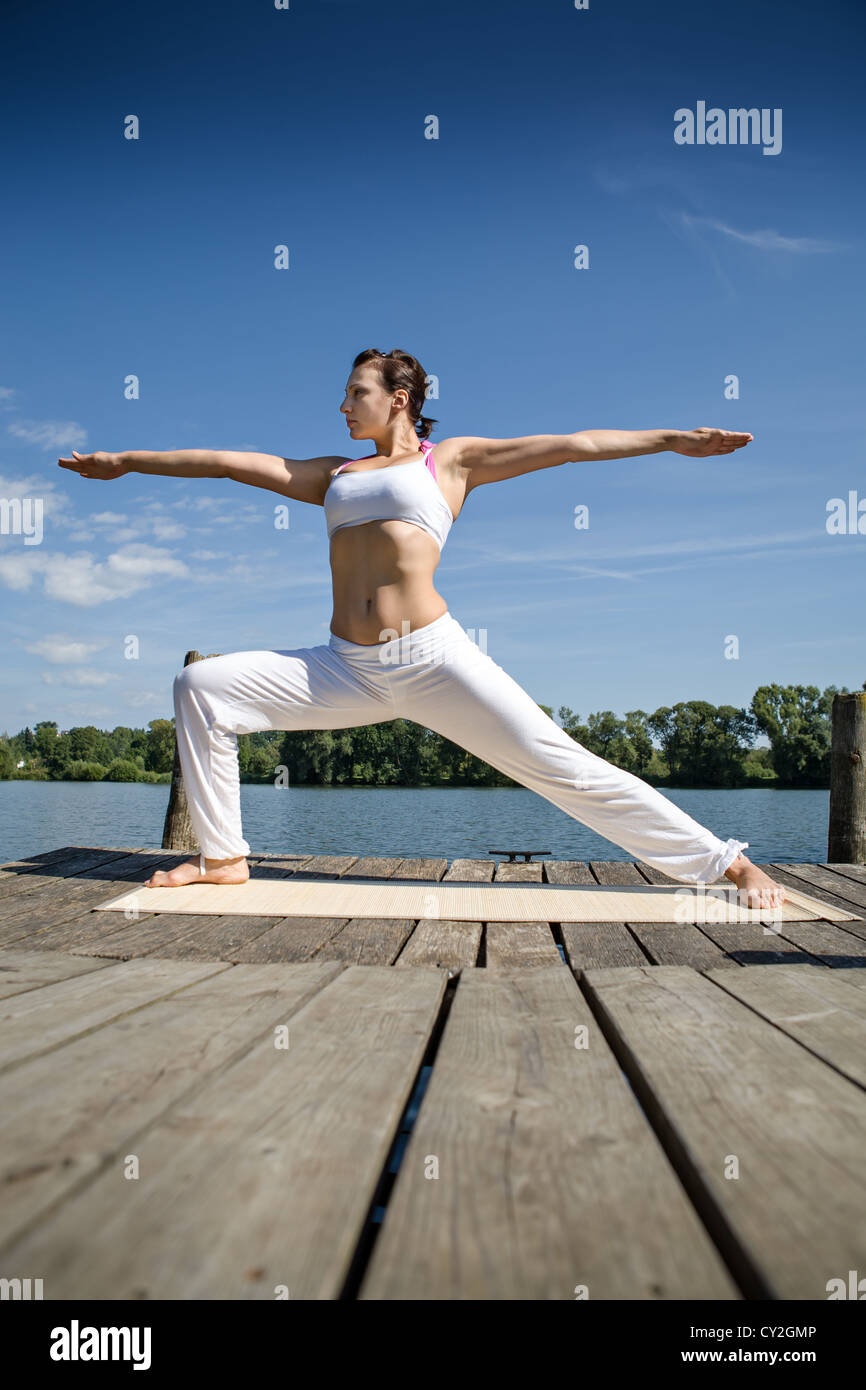 young woman making yoga exercise at a lake Stock Photo - Alamy