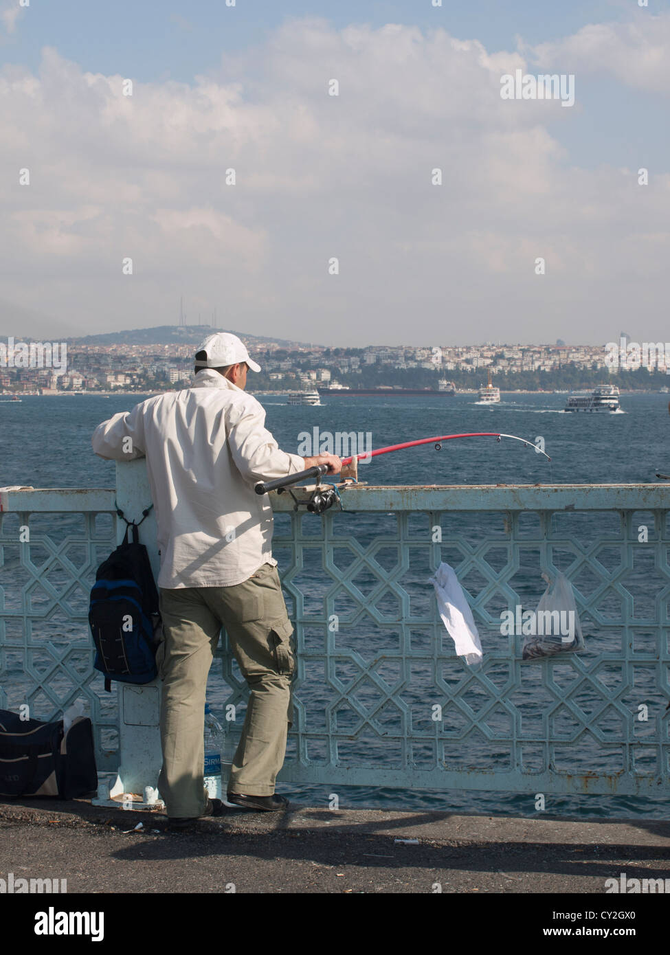 Sports-fisher hoping for a catch on the Galata bridge in Istanbul Turkey , Bosporus and the Asian side in the background Stock Photo