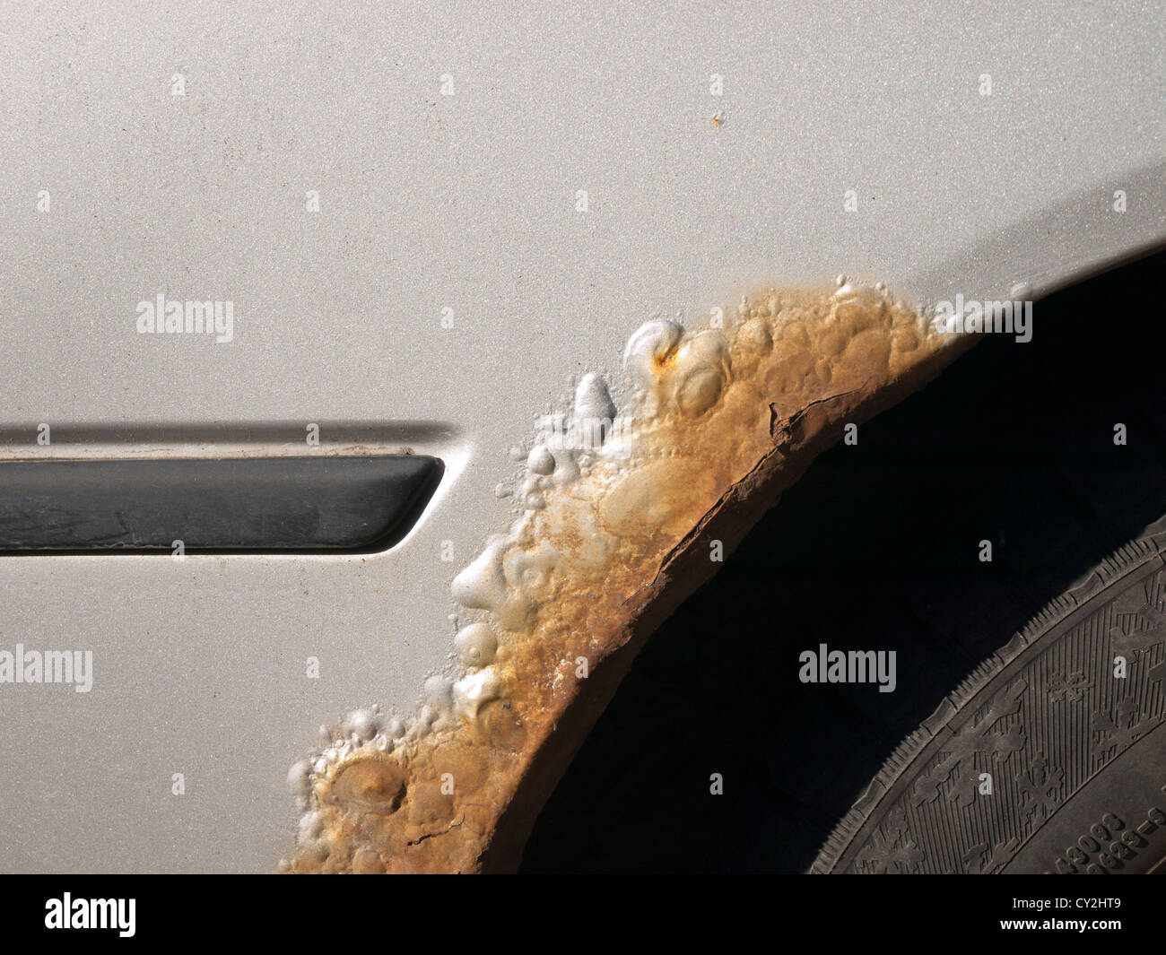 Rust and bubbles on car fender interferes with the gray metallic