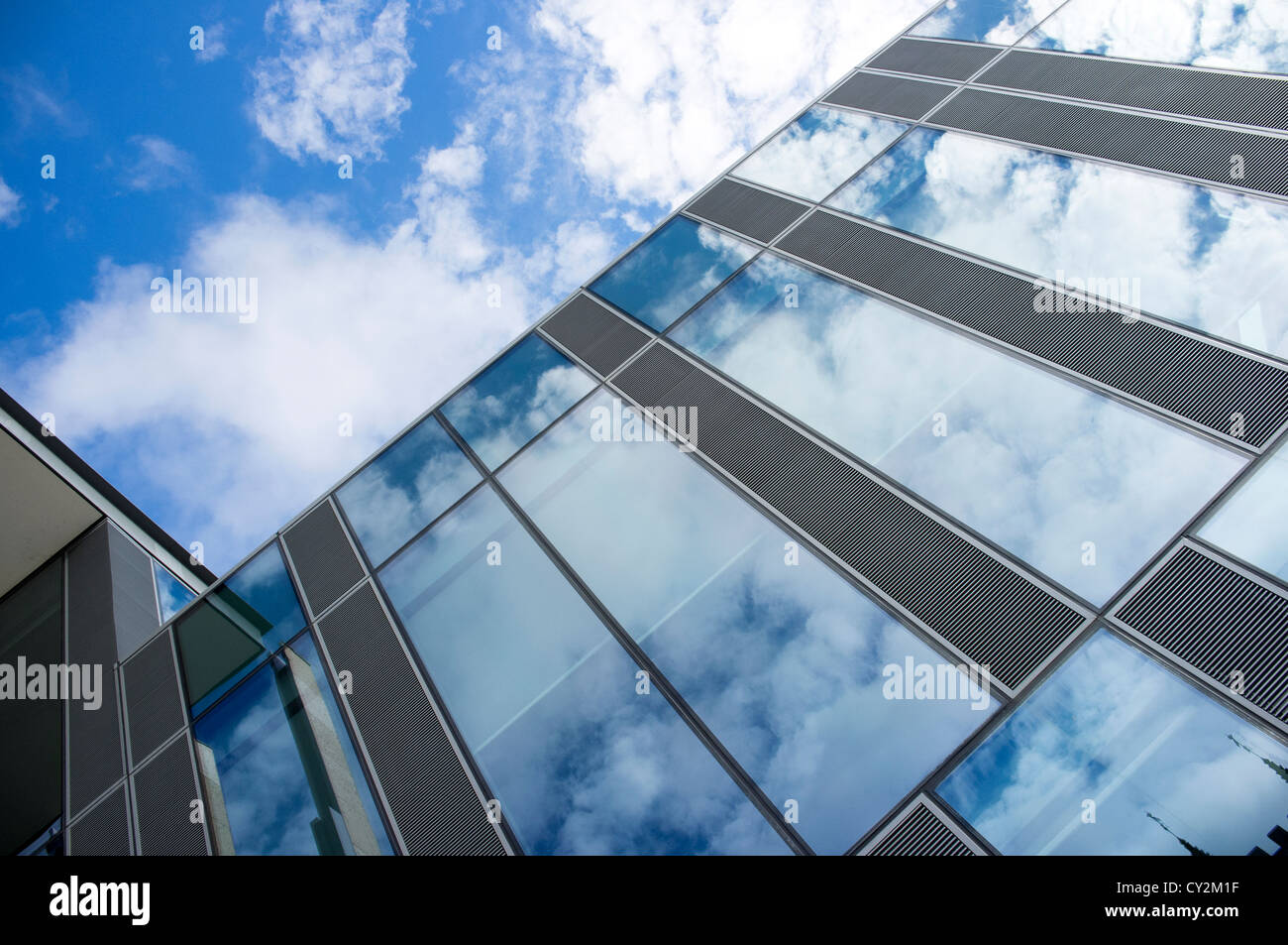 Sky and clouds reflected in the glass windows of a modern office ...