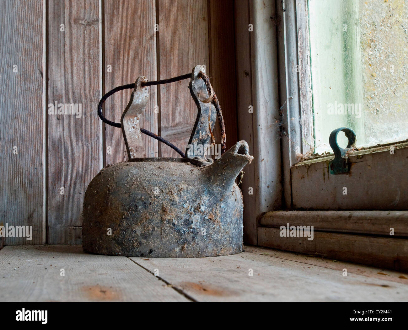 A cobweb encrusted kettle on the window sill of an abandoned cottage in the Highlands,Scotland Stock Photo