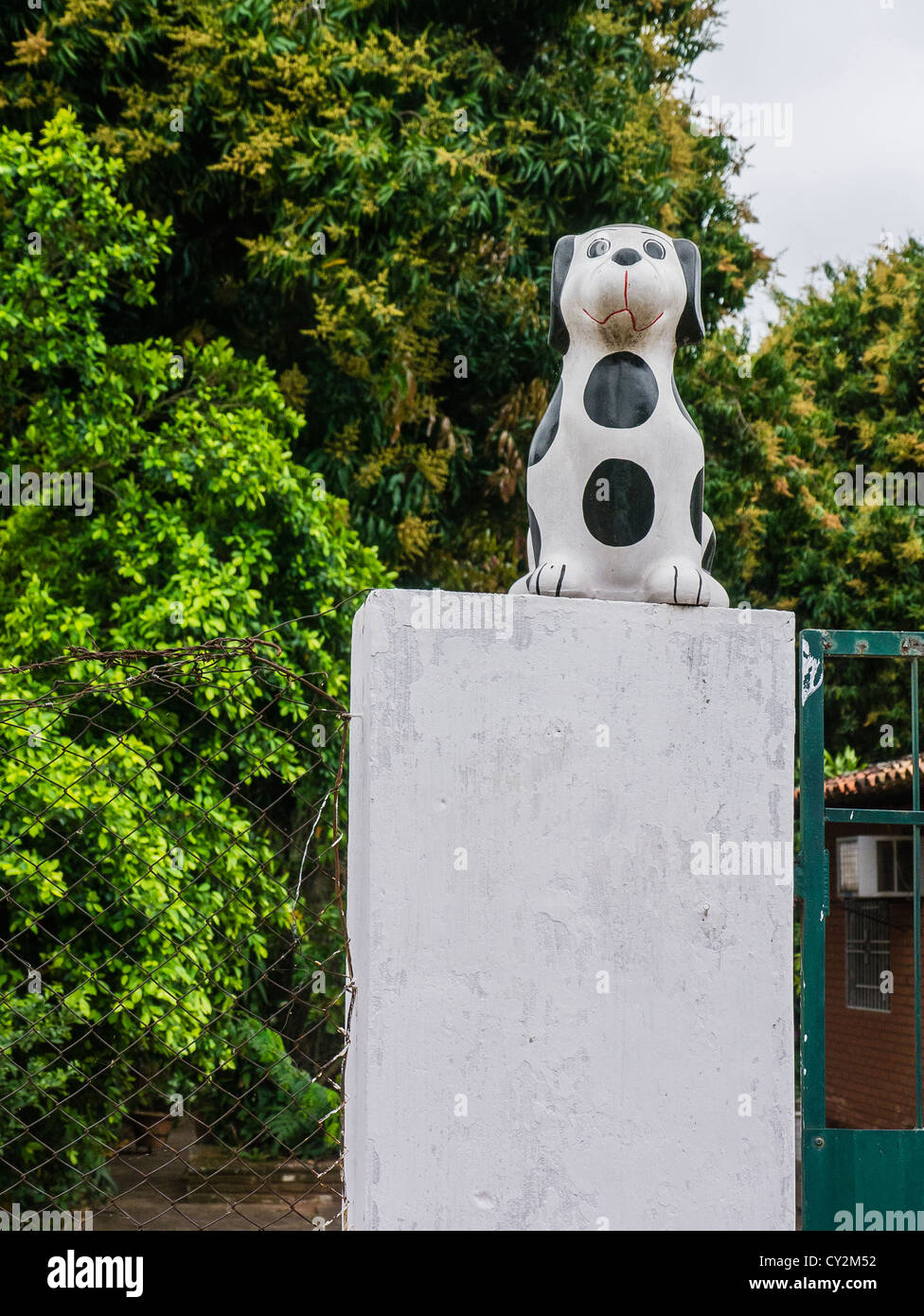 A black and white spotted kitsch lawn art dog outside on a pedestal in Asunción Paraguay. Stock Photo