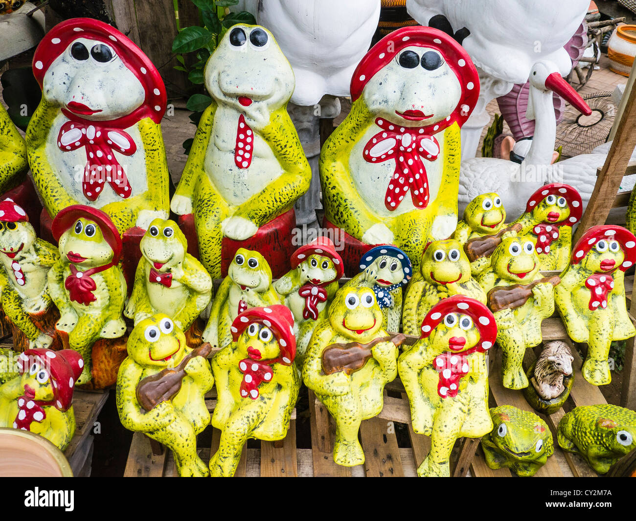 A group of silly looking yellow-green frogs kitsch lawn art for sale at a street market in Asunción Paraguay. Stock Photo