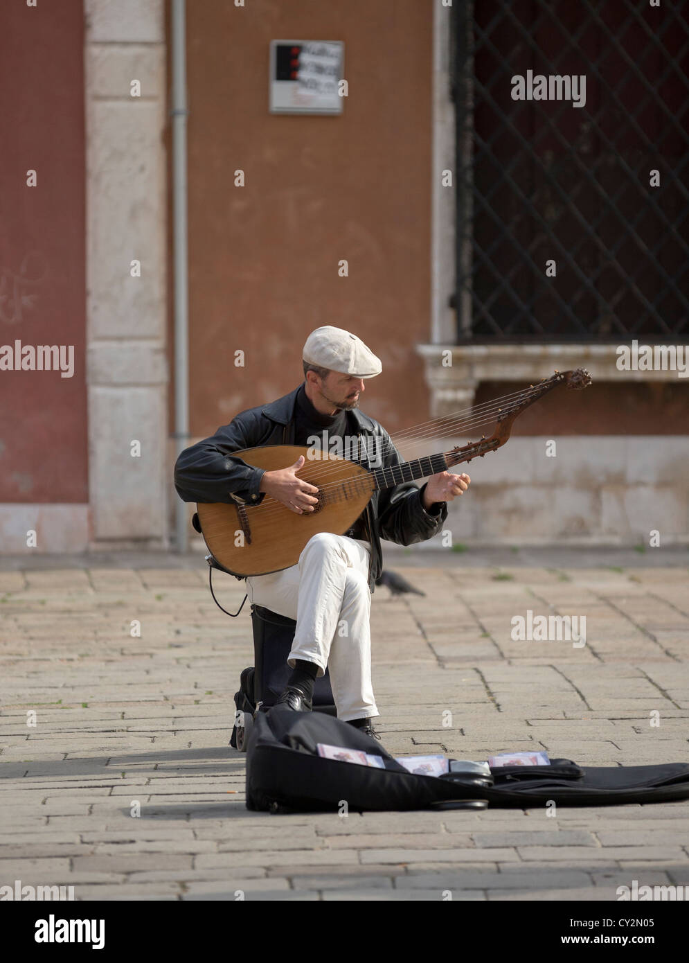 A street musician playing a long-necked lute with a second pegbox allowing unfretted strings (e.g. theorbo, angelique, torban) Stock Photo