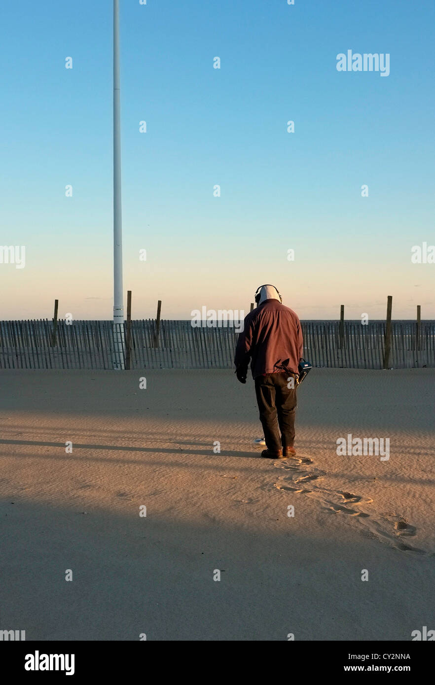 A man with a metal detector on the beach in Ocean City Maryland Stock
