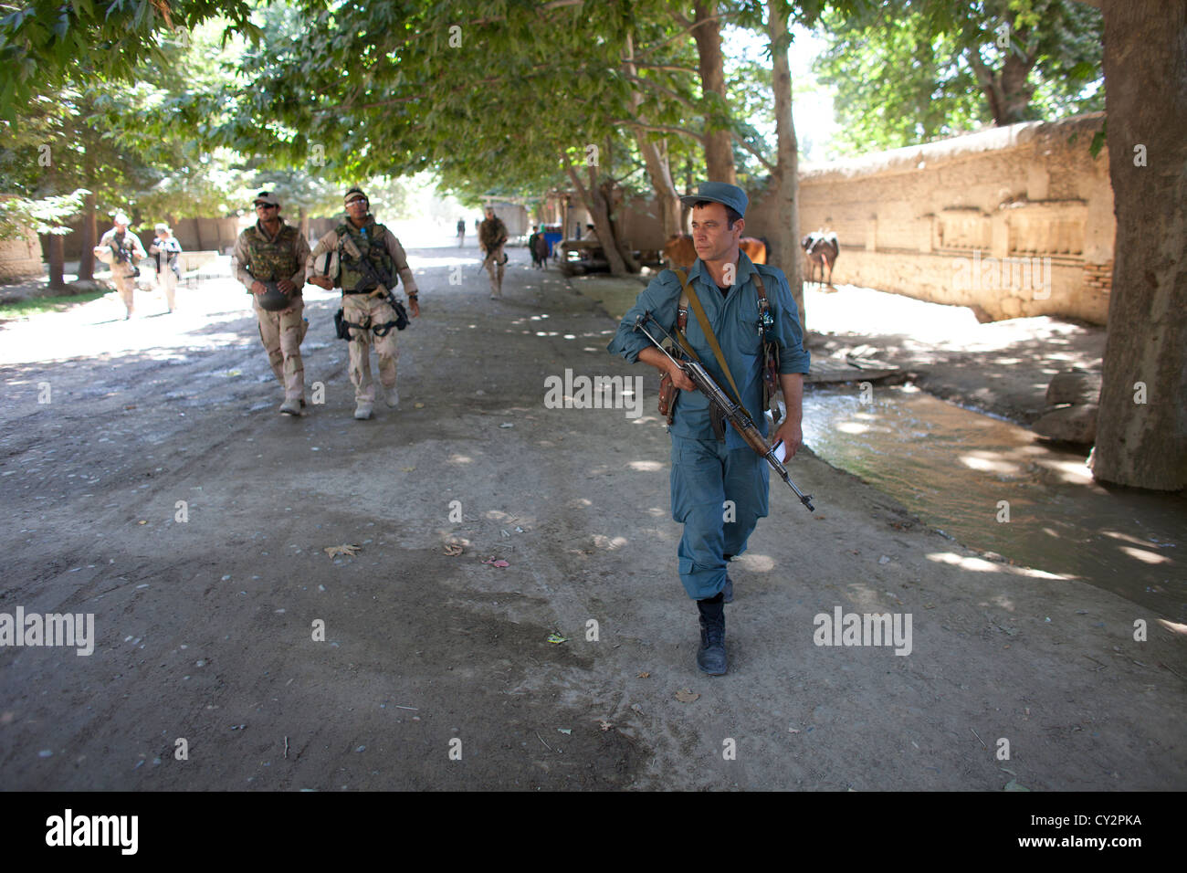 Afghan national Police officers walking patrol in Khanabad, Kunduz. Dutch military are supervising them. Stock Photo