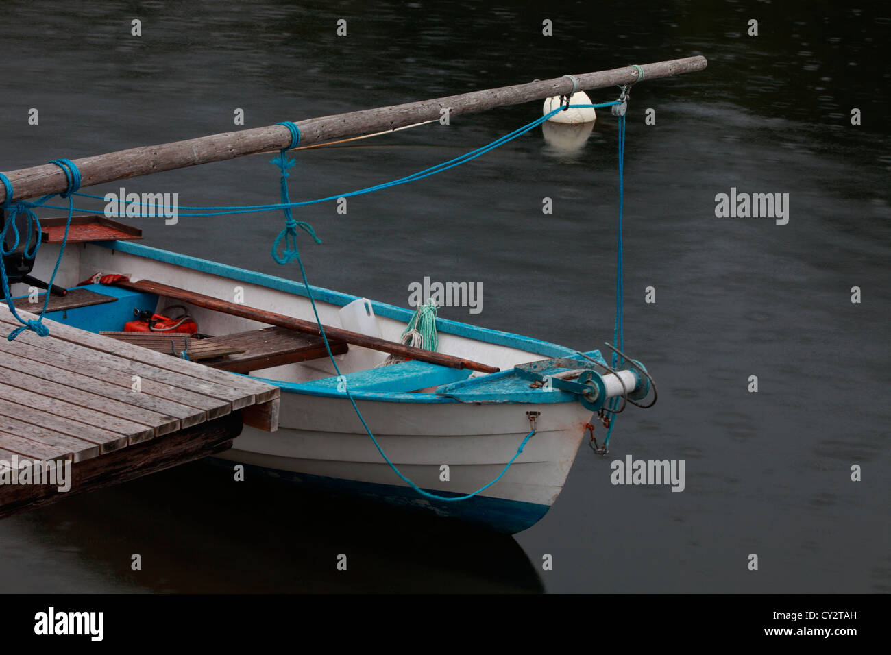 Rowing boat lying moored at a jetty in a fishing village in Sweden Stock Photo