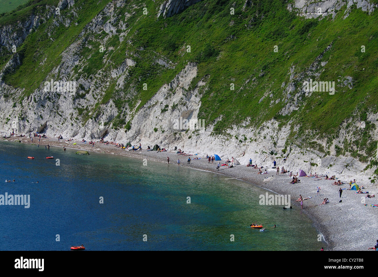 A view of Lulworth Cove Dorset with the bay, beach and bathers in the summer UK Stock Photo