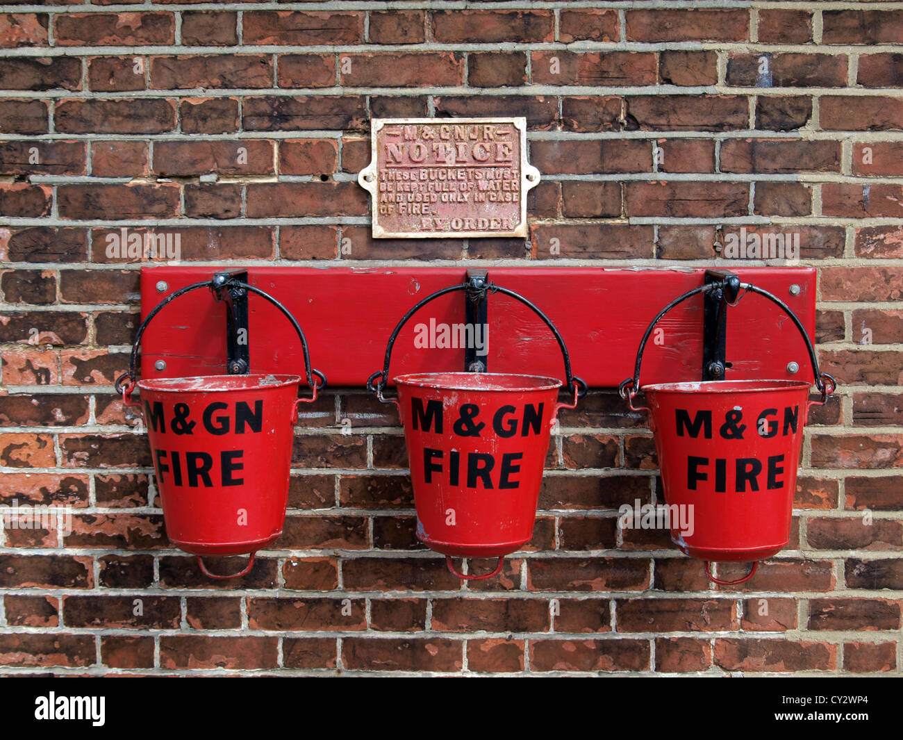 Three red fire buckets on the preservation railway at Sheringham in North Norfolk Norfolk England Stock Photo