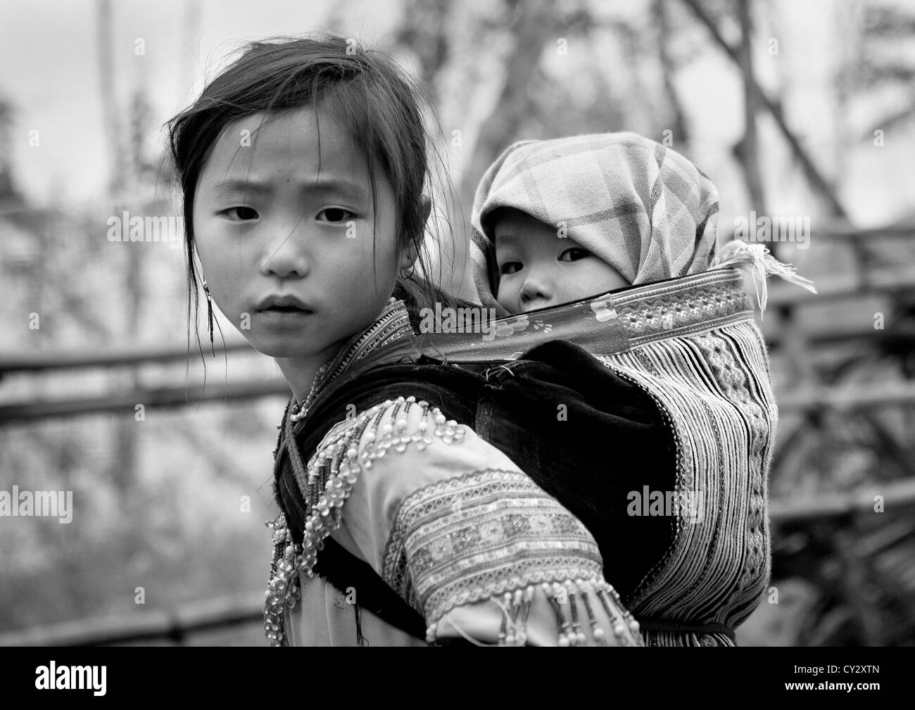 Flower Hmong Girl Carrying Her Baby Sister On Her Back, Sapa, Vietnam Stock Photo