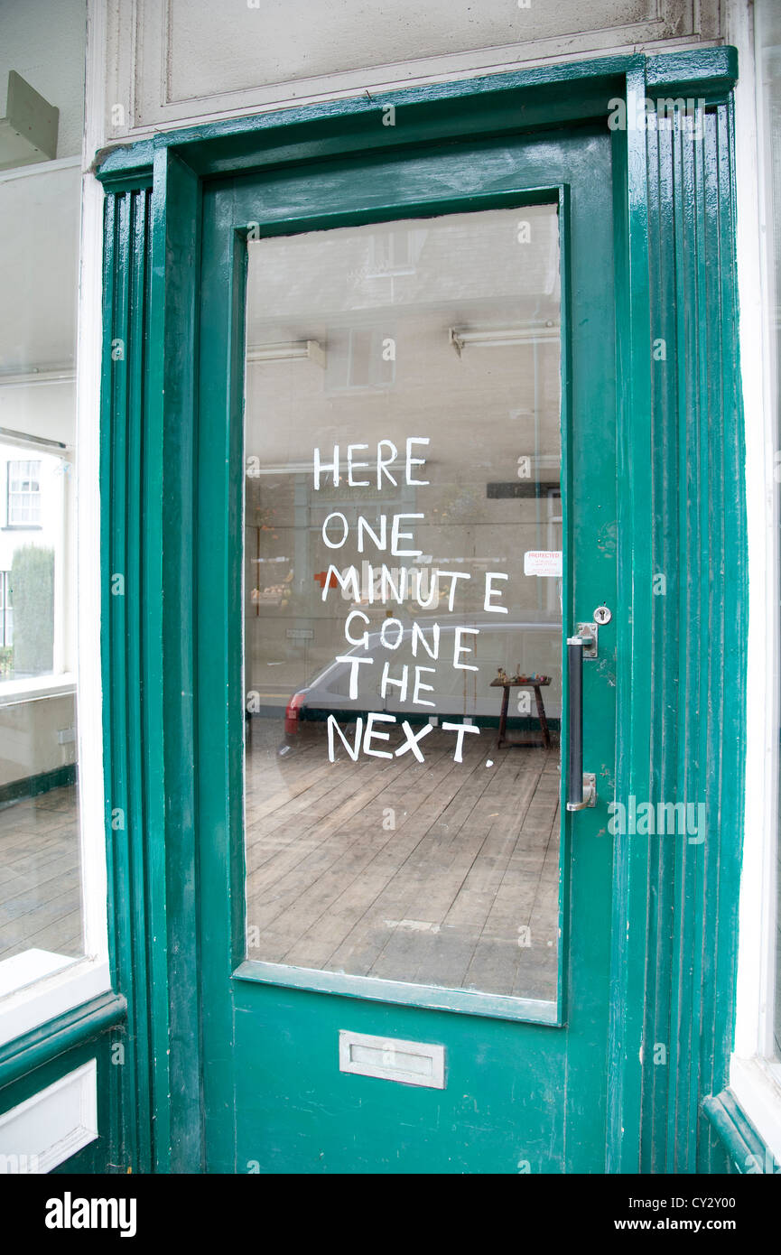 Empty shop premises with painted notice on the door. Here one minute gone the next Stock Photo