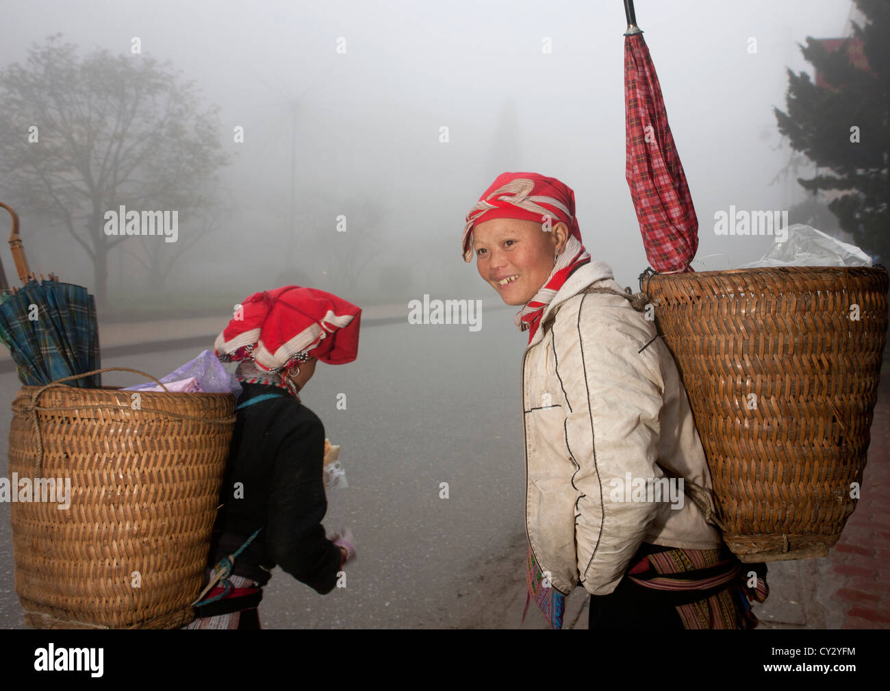 Red Dzao Women Carrying Umbrellas In The Baskets On Their Back, Sapa, Vietnam Stock Photo