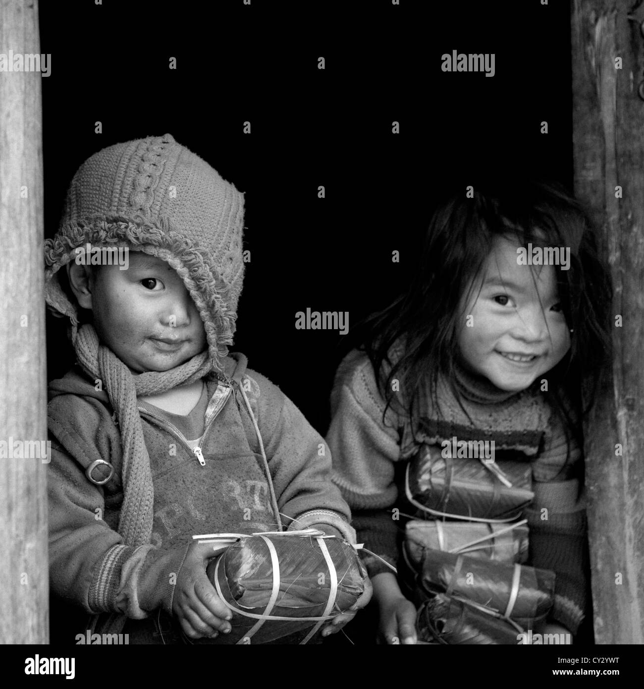 Black Hmong Kids Holding Wrapped Rice Cakes For Tet, Sapa, Vietnam Stock Photo