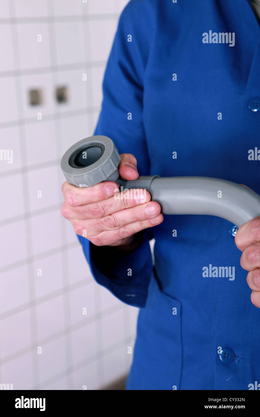 Plumber holding a grey pipe waste pipe and fitting Stock Photo Alamy