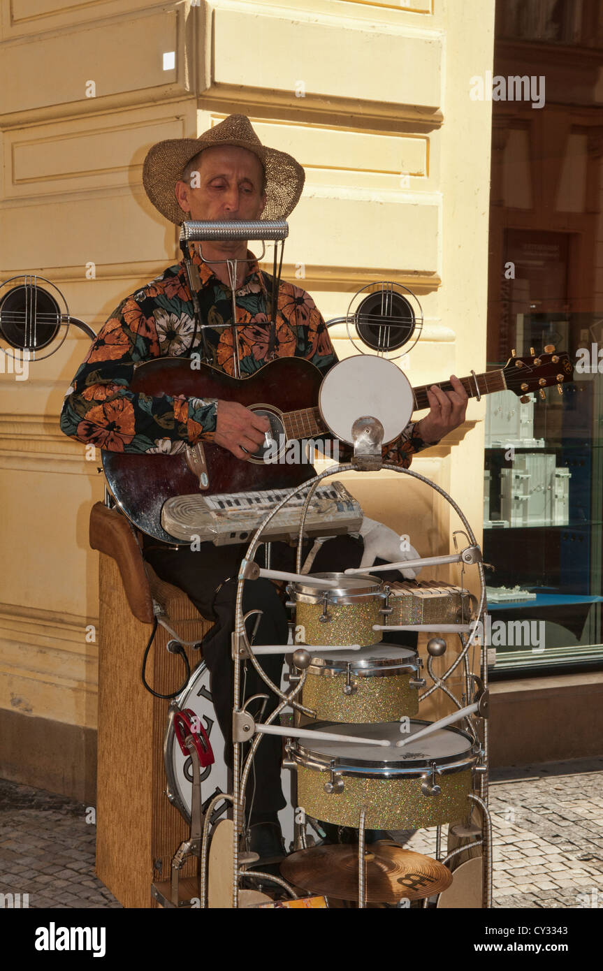 musician playing harmonica, drums, and other in the old town of Prague