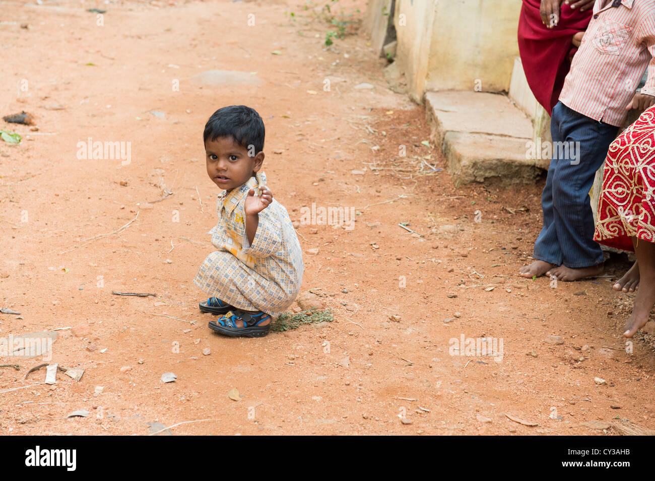 Small indian boy playing with a stick in a rural indian village. Andhra Pradesh, India Stock Photo