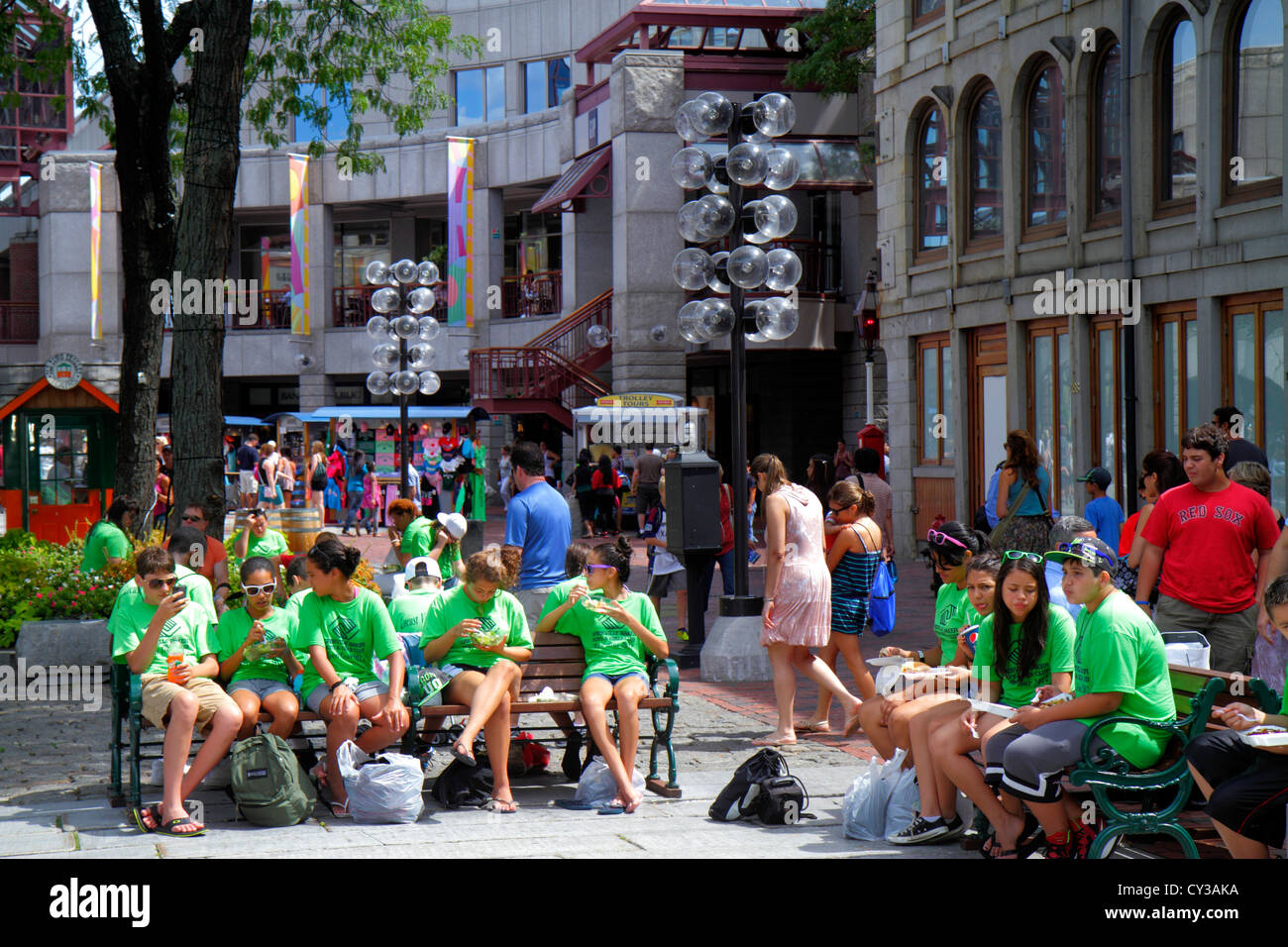 Boston Massachusetts,Faneiul Hall Marketplace,Quincy Market,teen teens teenager teenagers student students class field trip,public benches,eating,MA12 Stock Photo