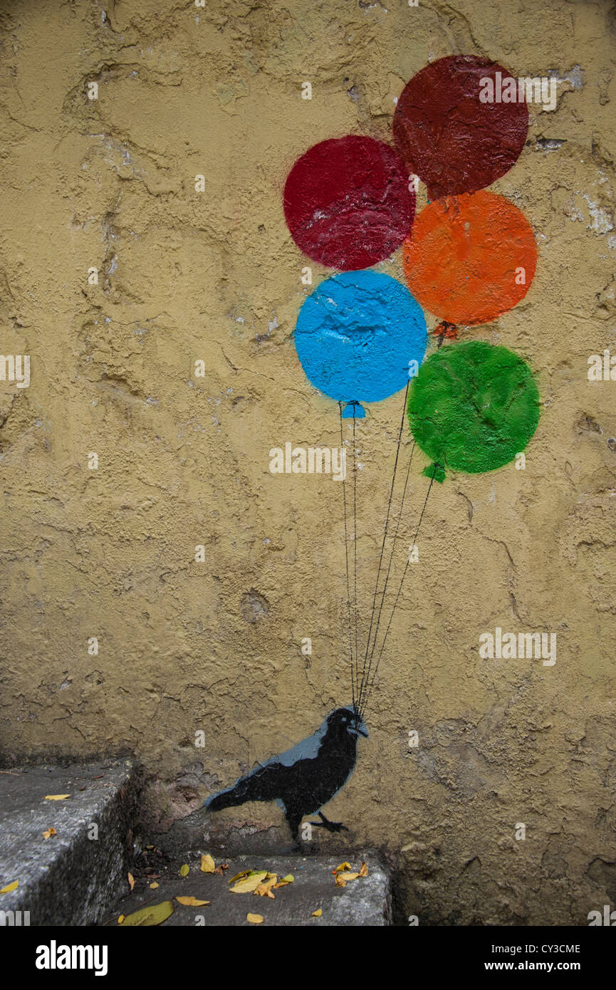 Funny painting of a crow bird holding a bunch of balloons on a staircase wall in Istanbul Turkey Stock Photo