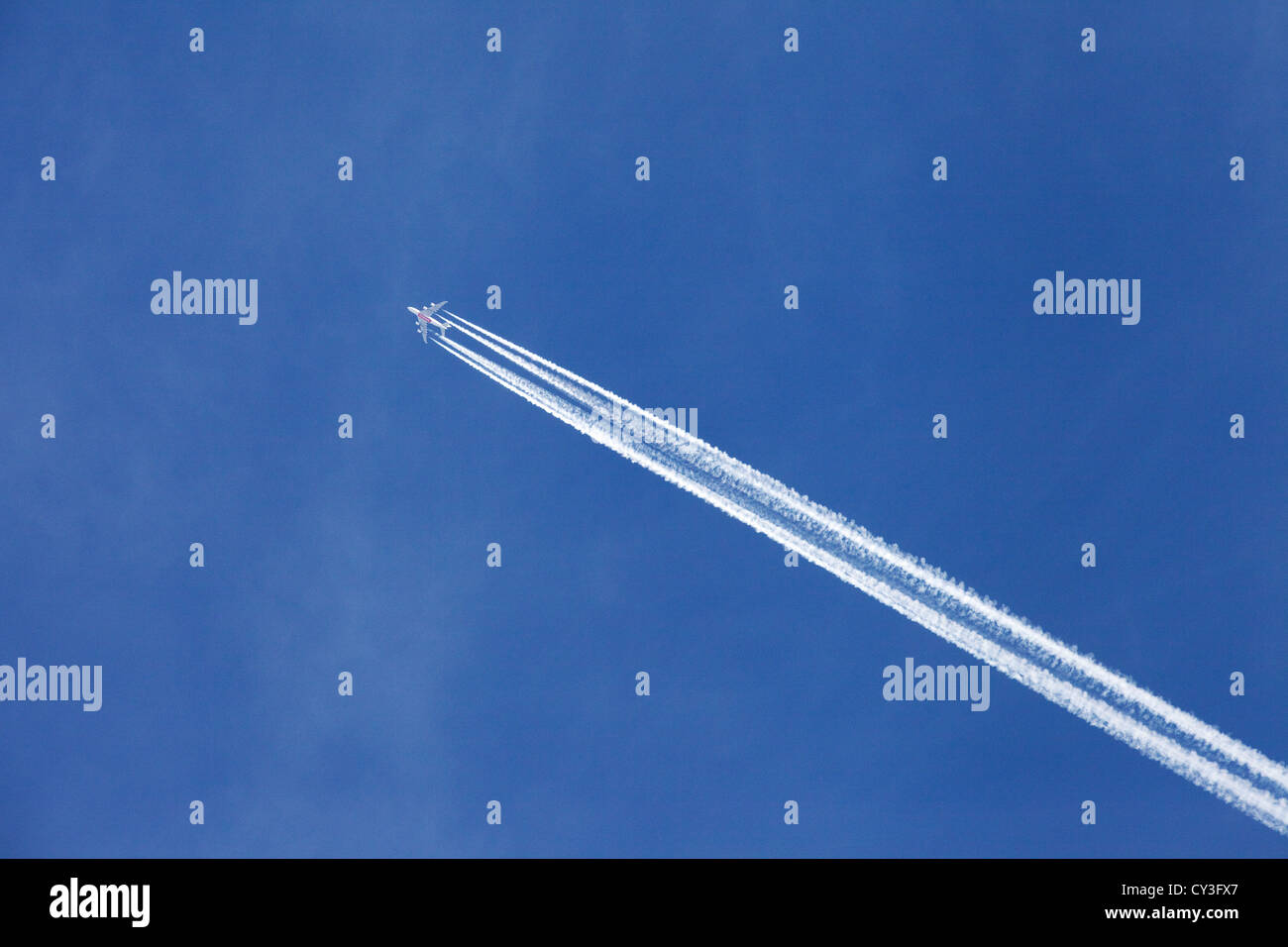 Airplane vapour trail from an Emirates plane against a blue sky Stock Photo