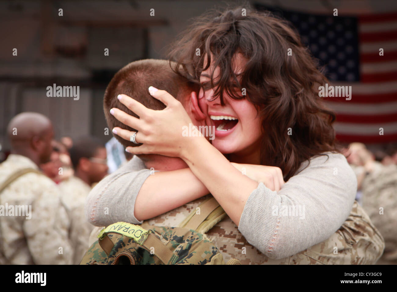 A US Marine hugs his wife during a return ceremony October 2, 2012 at the squadron hangar aboard Marine Corps Air Station Cherry Point, North Carolina. He was returning from a deployment in Afghanistan. Stock Photo