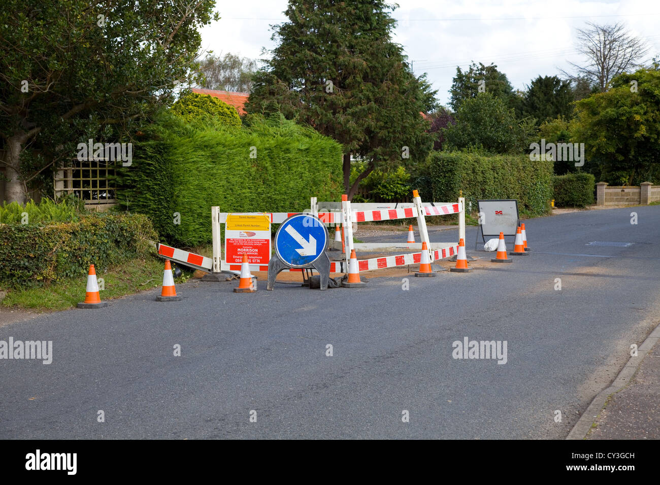 Urban British roadworks & lane closure with cones, watchman barriers & keep right sign & other signs on a B Road in Norfolk,UK. Stock Photo
