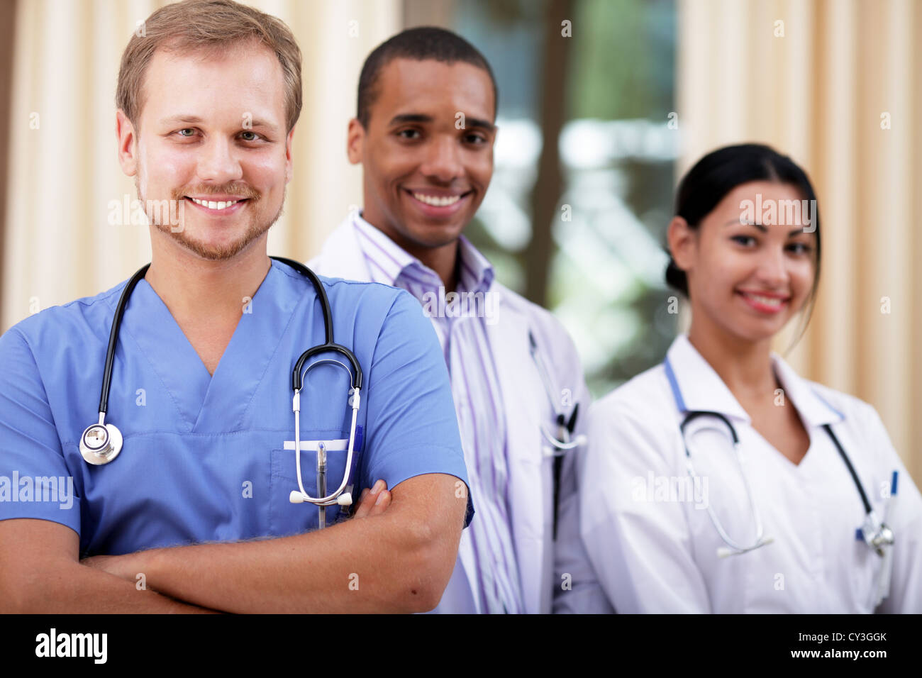 Doctor in blue scrubs with his colleagues behind Stock Photo Alamy