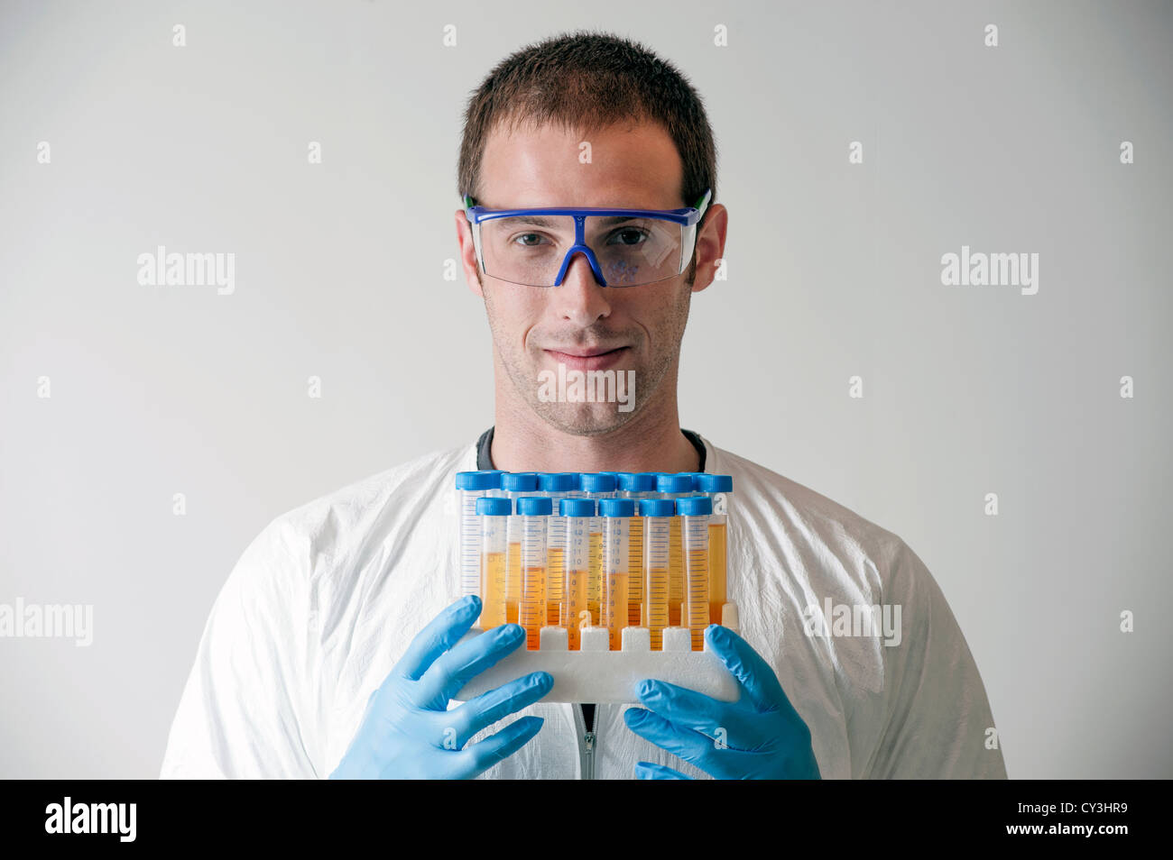 Male lab technician with test tubes filled with yellow liquid. Stock Photo