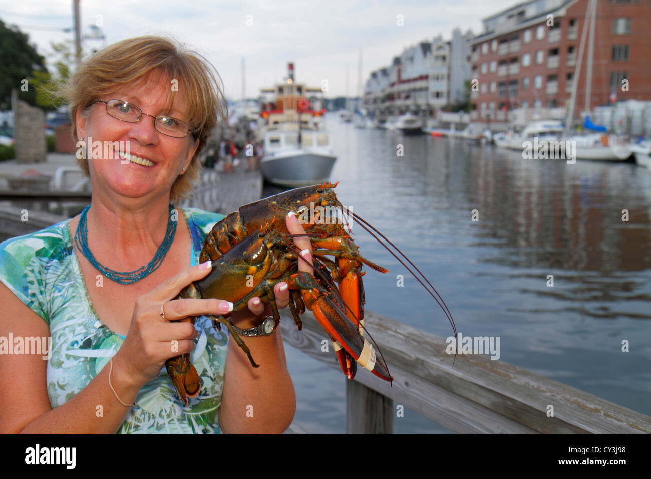 Portland Maine,historic Old Port District,Long Wharf,Lucky Catch Cruises,lobstering excursion,woman female women,holding,lobster,ME120824033 Stock Photo