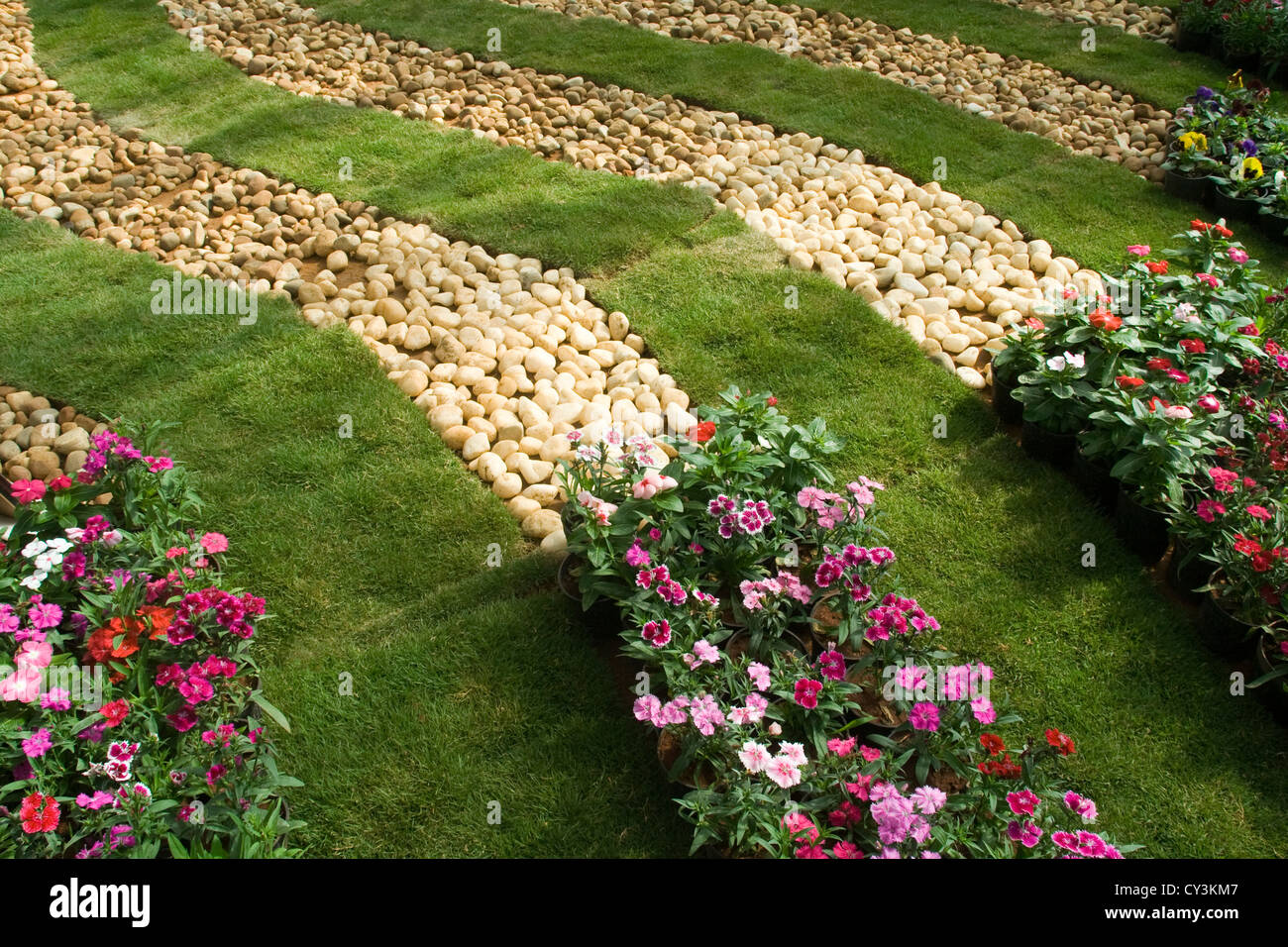 Neatly laid decorative bands of lawn, pebbles and flower beds Stock Photo