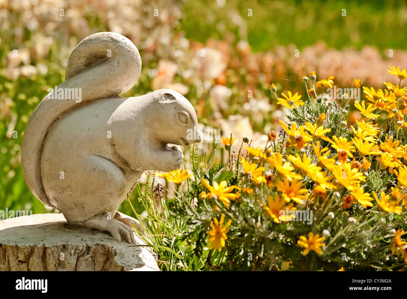 A Cute Stone Squirrel Statue Made of Stone in a Yard Setting With